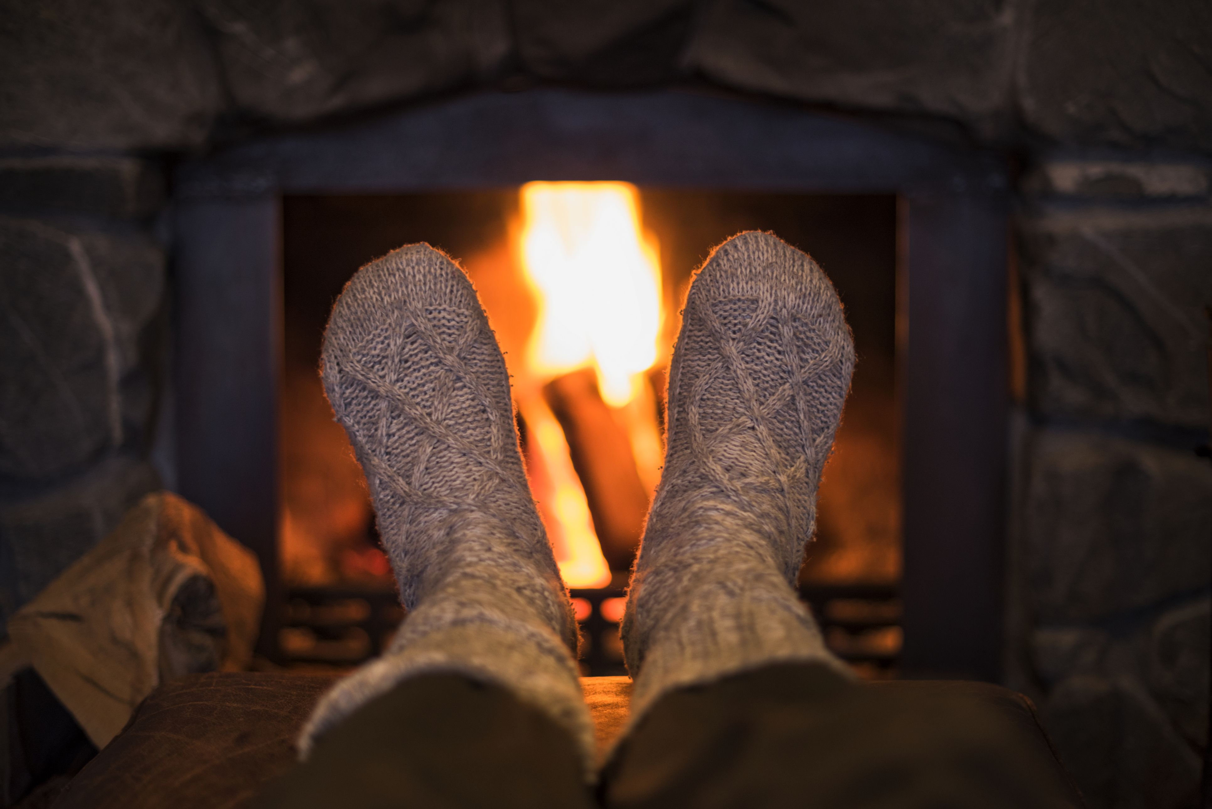 Feet in wool socks near fireplace