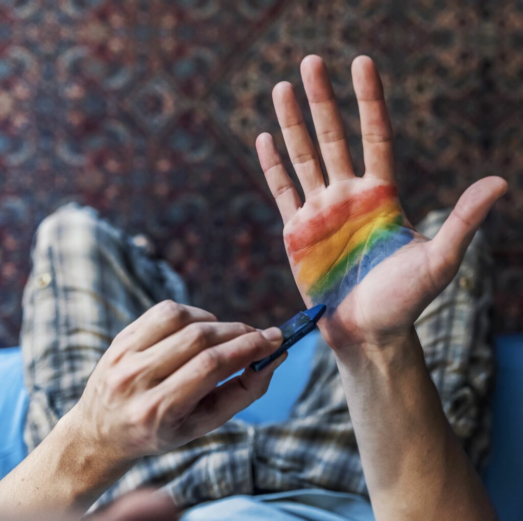 ¿La sexualidad de una persona está ligada a la forma de sus manos? 1 man painting lgbt flag on palm of his right hand royalty free image 981640876 1540754180 ¿La sexualidad de una persona está ligada a la forma de sus manos?