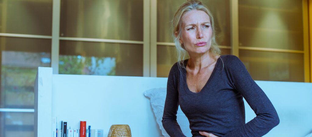 ¿Miedo al dolor? Nunca más 1 mature woman sitting on bed with hands on stomach royalty free image 951222884 1552653280 ¿Miedo al dolor? Nunca más