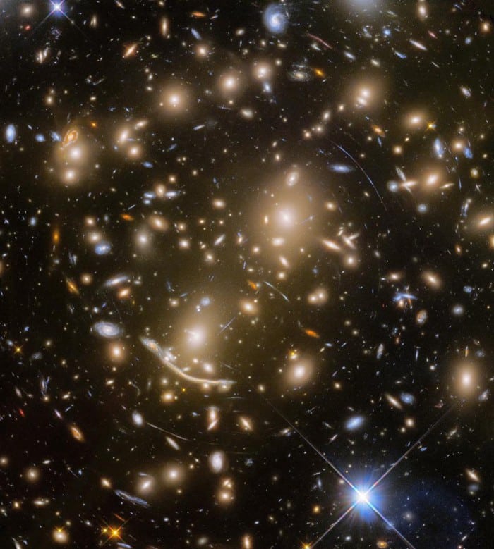 Las rayas y arcos presentes en Abell 370, un cúmulo de galaxias distante a unos 5.000 o 6.000 millones de años luz, son una de las pruebas más sólidas que tenemos de las lentes gravitacionales y la materia oscura. Las galaxias con lente son aún más distantes, y algunas de ellas constituyen las galaxias más lejanas jamás vistas. El programa Frontier Fields busca galaxias con lentes mediante imágenes profundas de cúmulos de galaxias. (NASA, ESA/HUBBLE, HST FRONTIER FIELDS)