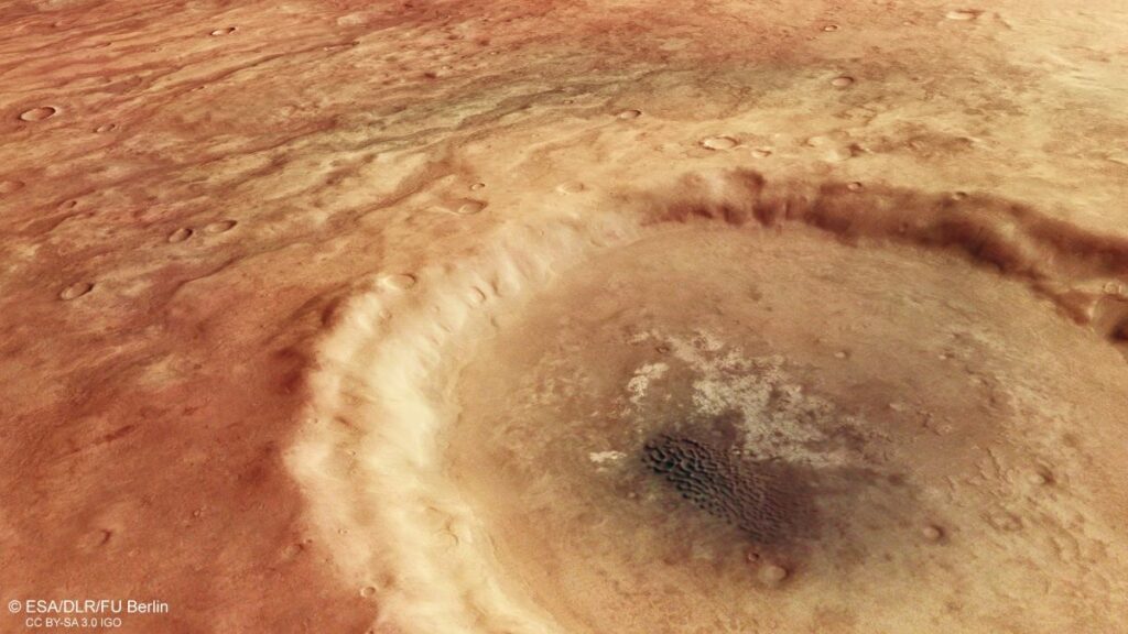 Dentro del cráter, un campo de dunas oscuras descansa sobre una superficie más clara